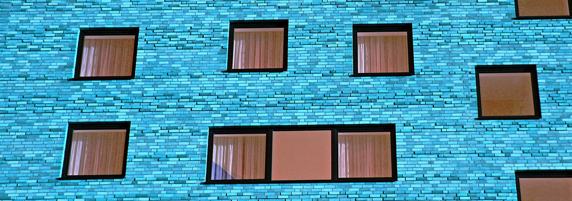 Bright blue brick building with many square windows