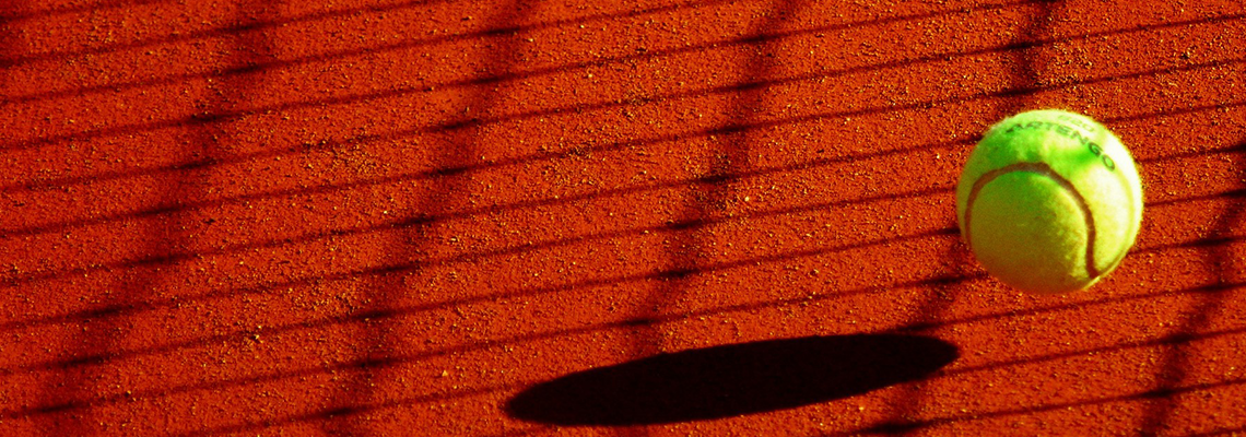 Tennis ball in the shadow of the court net